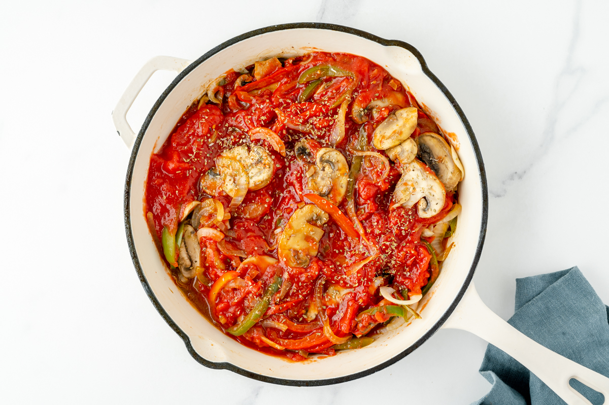 veggies and red sauce cooking in pan
