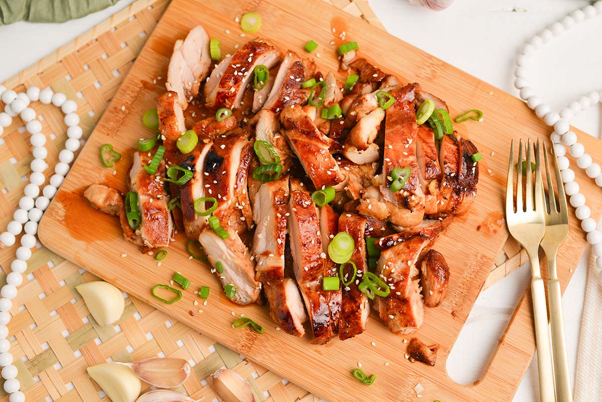 overhead shot of slice of asian chicken marinated chicken on cutting board