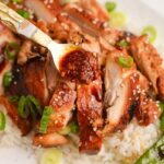 spoon adding sauce to chicken