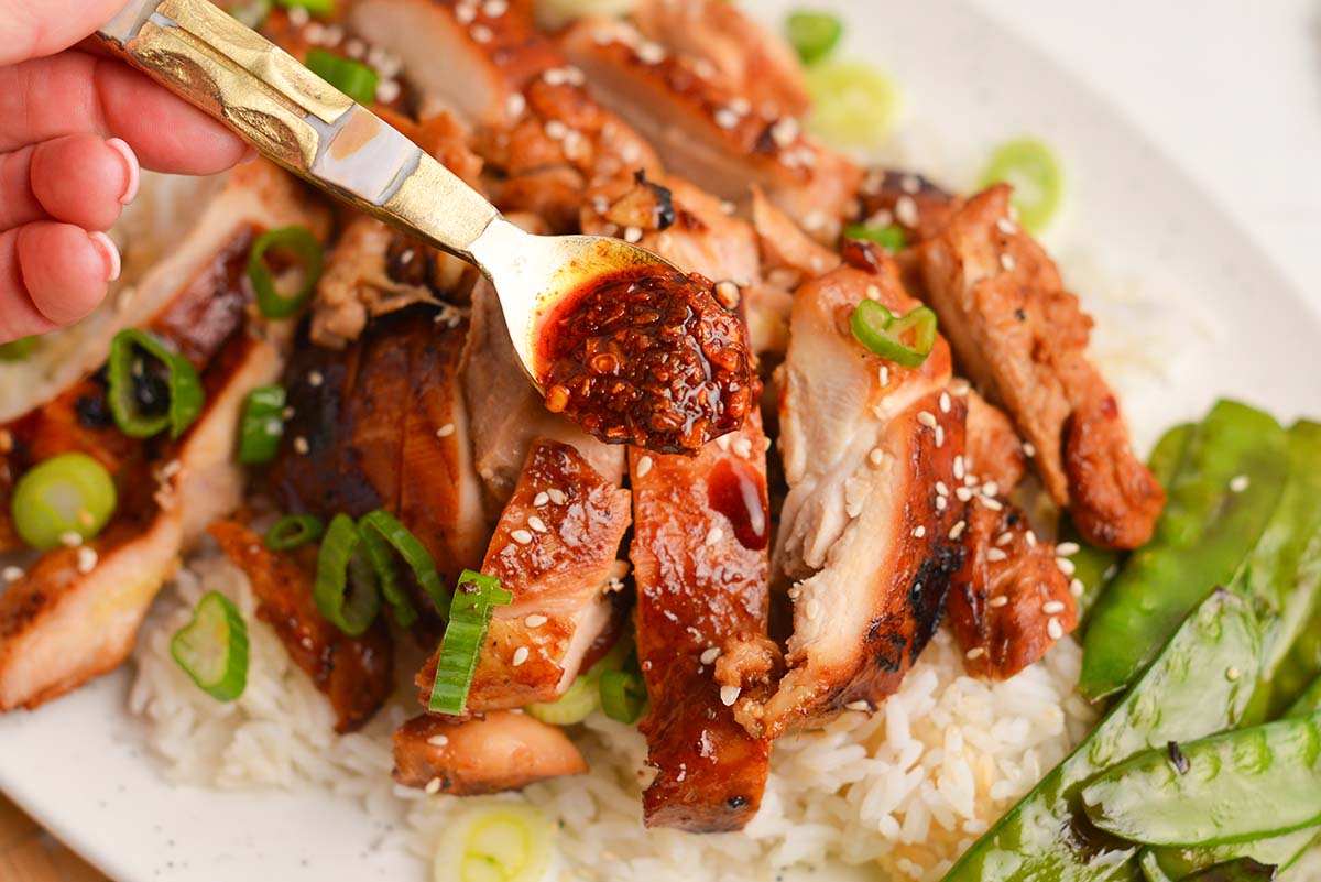 spoon adding sauce to chicken