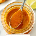 angled shot of spoon of orange sauce over jar with text overlay