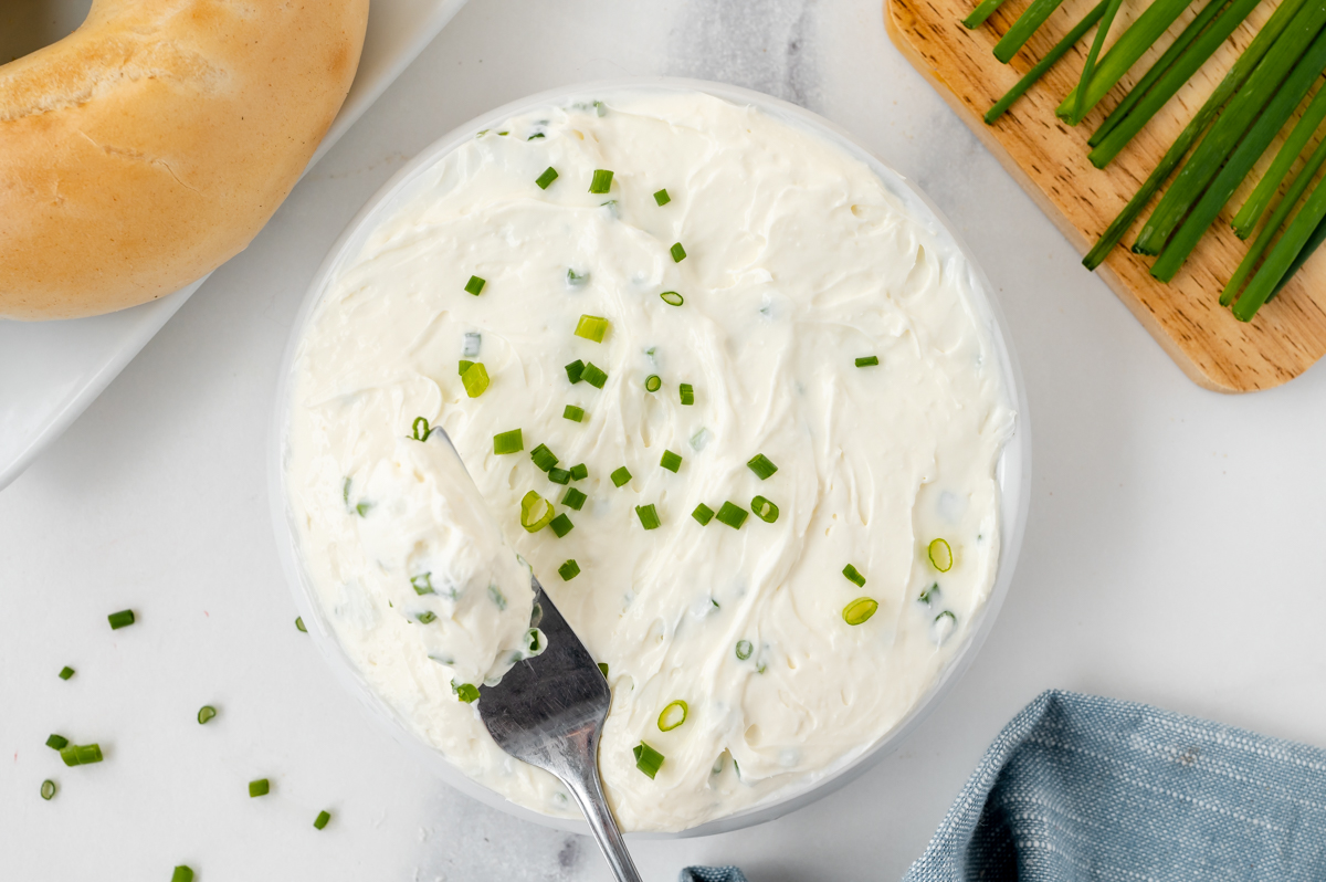 overhead shot of knife in bowl of savory cream cheese