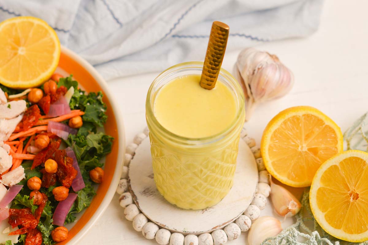 angled shot of spoon in jar of lemon vinaigrette