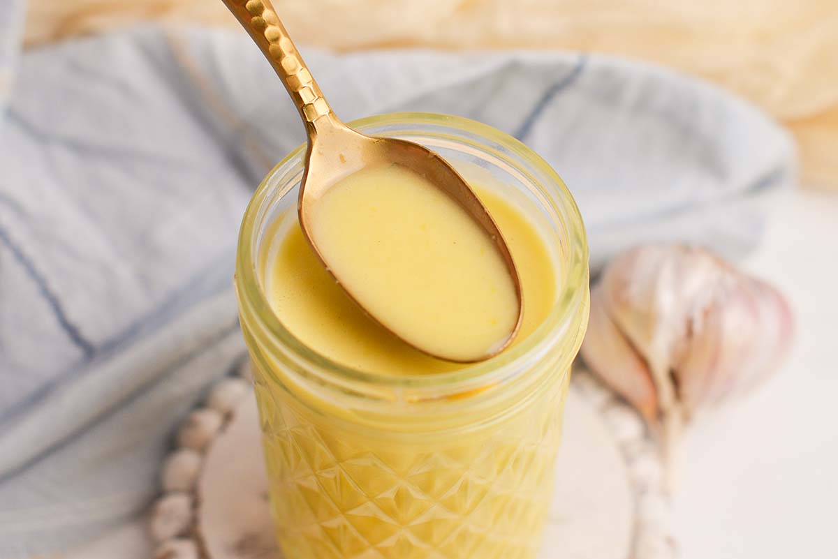 close up angled shot of spoon in jar of dressing