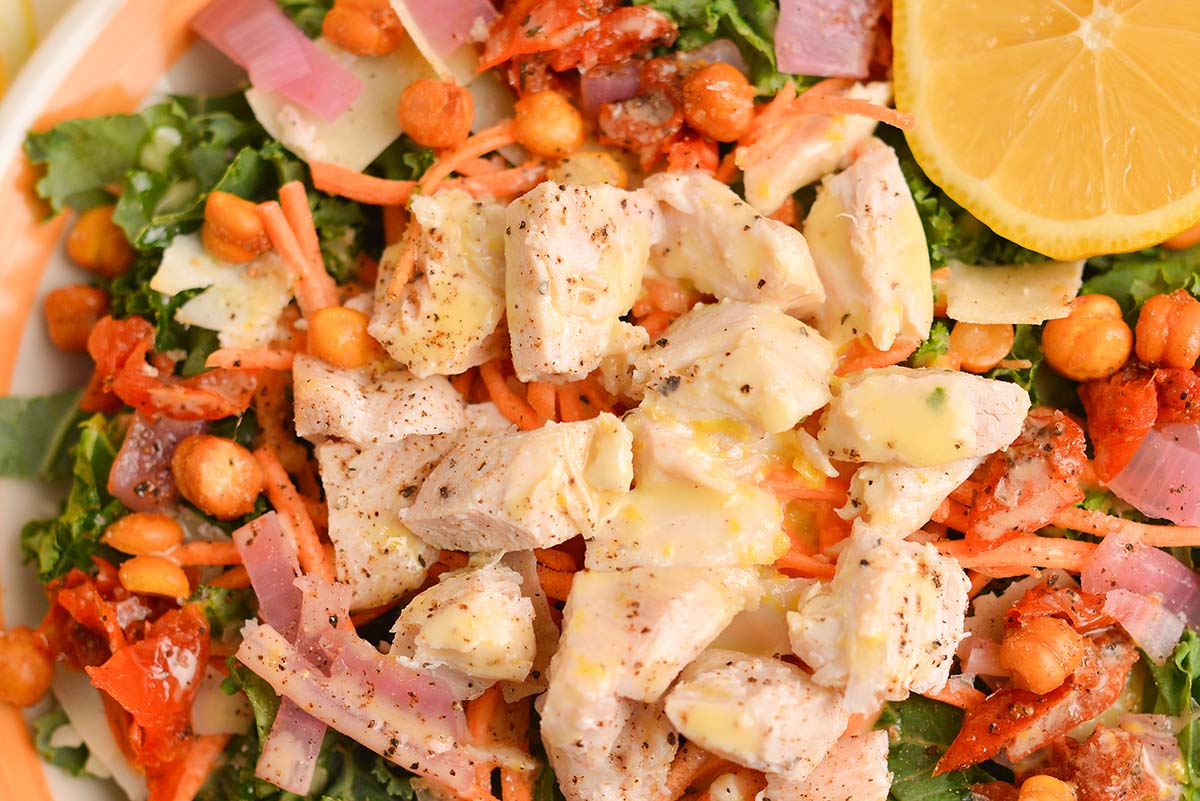 close up of dressing and chicken on salad