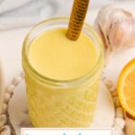 angled shot of spoon in jar of lemon vinaigrette with text overlay