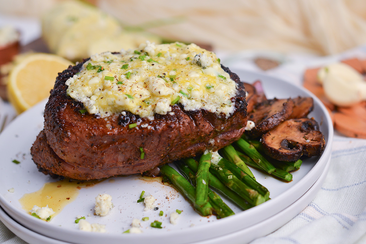 plate of steak topped with butter