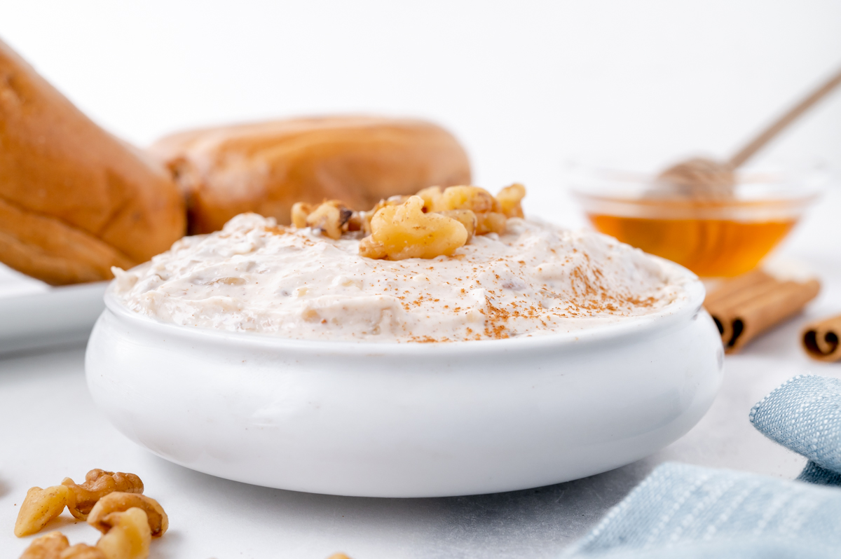 straight on shot of bowl of sweet honey walnut cream cheese with cinnamon and walnuts