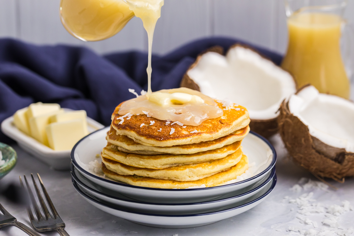 Coconut sauce for pancakes poured over a breakfast stack