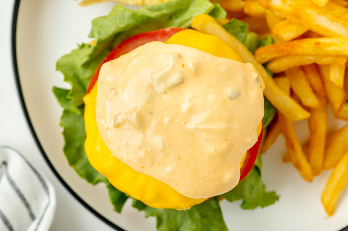 secret sauce for burgers spread on cheeseburger